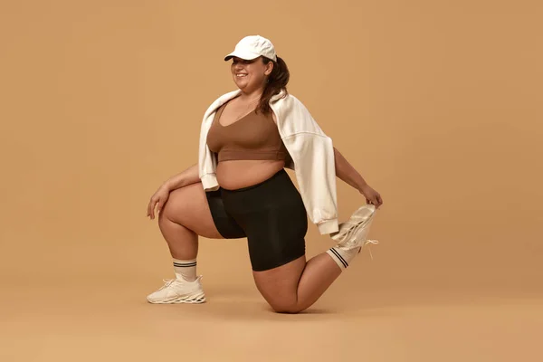 Junge Übergewichtige Frau Lächelt Posiert Stylischer Sportkleidung Mütze Und Kapuzenpulli — Stockfoto