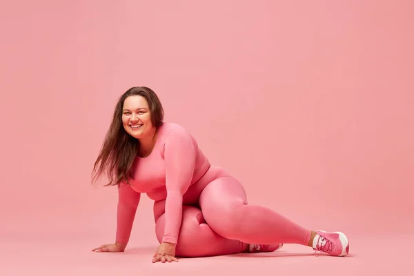 自我照顾和幸福 年轻超重女子运动服训练背景为粉红工作室 体格积极 体重减轻 身体和保健的概念 — 图库照片