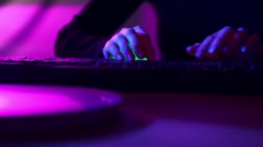 Erkek ellerinin hızlı bir şekilde evdeki bilgisayar klavyesine, neondaki ofise basması. Çevrimiçi iş, serbest çalışma, programcı, gazeteci. İş anlayışı, oyun, modern teknolojiler, serbest çalışma