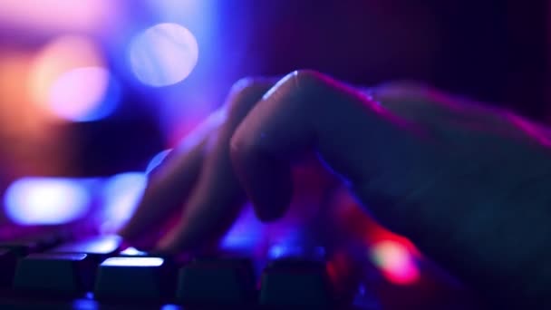 男性の手のクローズアップ オンラインゲームをプレイするためにコンピュータバックライトキーボードを使用してサイバースポーツマン ネオンが背景を照らした サイバースポーツ オンラインゲーム 現代技術 フリーランスの概念 — ストック動画