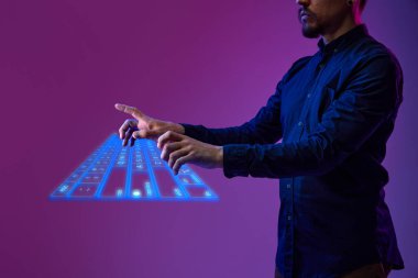İş adamı, programcı sanal, dijital, kablosuz klavye kullanıyor. Yenilik, siber uzay, bilgisayar aletinin holografik görüntüsü. İş kavramı, modern teknolojiler, ağ ve dijitalleşme