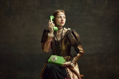 Eski moda elbiseli genç bir kızın portresi, eski telefondan koyu yeşil arka planda konuşan asil bir insan. İletişim. Tarih kavramı, Rönesans sanatı, dönemin karşılaştırması.