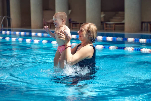 Szczęśliwa Uśmiechnięta Dziewczynka Dziecko Bawiące Się Krytym Basenie Babcią Pływanie — Zdjęcie stockowe