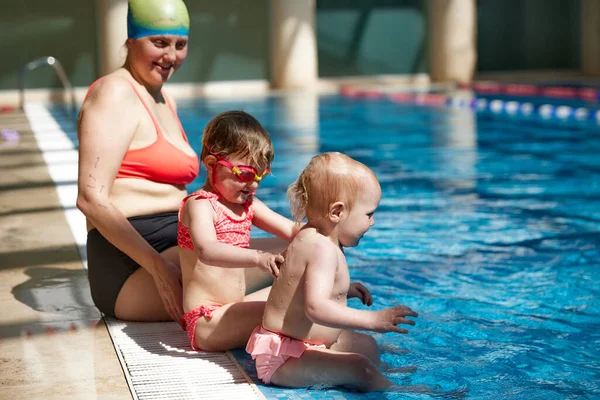 Glückliche Mutter Badeanzug Und Mütze Pool Sitzend Mit Ihren Kleinen — Stockfoto