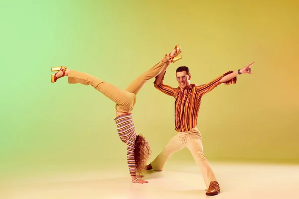 舞蹈摄影 两个有才华的人 自闭症男人和穿着老式衣服的女人 在渐变的绿色背景下跳舞 复古风格的概念 迪斯科舞 业余爱好 70年代 — 图库照片