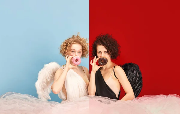 Retrato Mulheres Bonitas Trajes Anjo Demônio Posando Com Donuts Contra — Fotografia de Stock