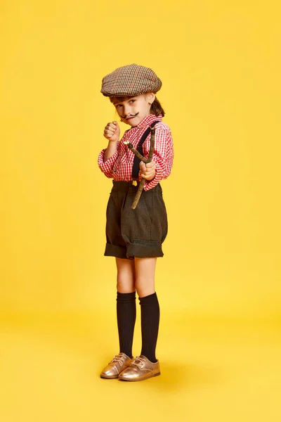 Portret Dziewczynki Dziecka Retro Koszuli Spodenkach Trzymającego Procę Żółtym Tle — Zdjęcie stockowe