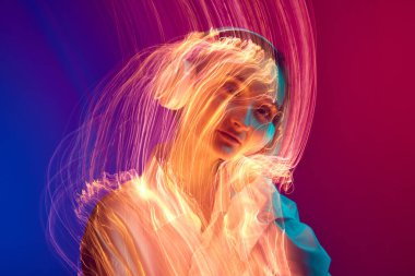 Kulaklıkla müzik dinleyen genç bir kızın portresi, karışık neon ışık efektiyle gradyan arka planda poz veriyor. Sanat anlayışı, modern tarz, siber punk, fütürizm ve yaratıcılık