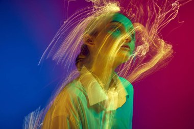 Gradyan mavi pembe stüdyo arka planında neon ışık efektiyle poz veren genç bir kızın portresi. Yaratıcı vizyon. Sanat anlayışı, modern tarz, siber punk, fütürizm ve yaratıcılık