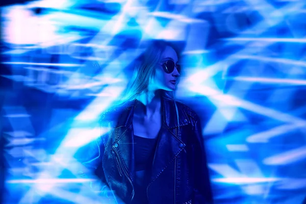 抽象的なネオンの要素で青の背景にポーズ革のジャケットの若い美しい少女の肖像画 集中しない効果 近代的なスタイル サイバーパンク 未来主義と創造性の概念 — ストック写真