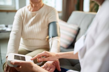 Yaşlı kadının baskısını ölçen kadın doktor, modern elektronik cihazlı hasta. Randevu. Kesilmiş yakın plan görüntü. Tıbbi bakım, ilaç, hastalık, sağlık, meslek kavramı