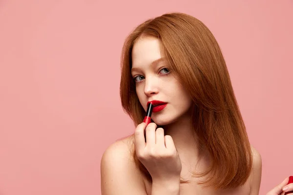 ピンクのスタジオの背景に赤い口紅を適用し よく保たれた肌を持つ若い 美しく 赤毛の女の子の肖像画 自然の美しさ 化粧品 化粧品 スキンケアの概念 — ストック写真