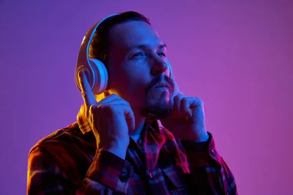 Портрет Молодої Людини Картатій Сорочці Слухає Музику Навушниках Фіолетовому Студійному — стокове фото