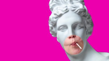 Hareket etmeyi, animasyonu durdurun. Antik kadın heykeli kafası, kızların ağzının bir kısmı pembe arka planda lolipop yiyor. Modern tasarım. Çağdaş sanat. Yaratıcılık, duygular, mizah, eğlence. Metin için alanı kopyala