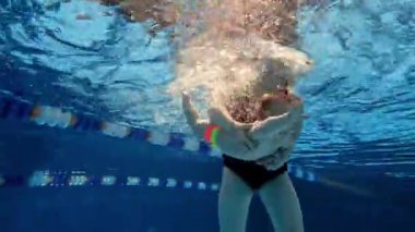 Şirin, güzel, küçük bir kız bebek, annesi kucağında yüzme havuzunda yüzen bir bebek. Su sporları aktivitesi. Spor, sağlıklı ve aktif yaşam tarzı, çocukluk, eğlence ve eğitim kavramı