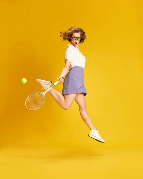 全长肖像画年轻的活跃女孩在运动服跳跃与网球球拍黄色工作室背景 体育的概念 积极的生活方式 — 图库照片