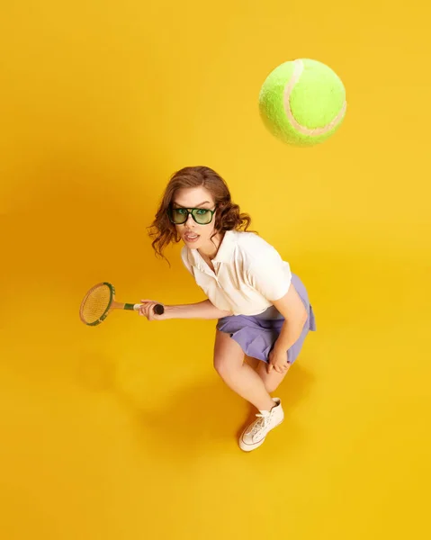 年轻集中的女孩的头像 漂亮的网球选手在运动 击中球与球拍黄色工作室背景 体育的概念 积极的生活方式 — 图库照片