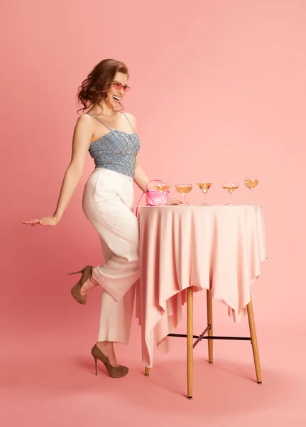 테이블에 분홍색 스튜디오 배경에 샴페인 안경을 아름다운 여성의 초상화 아름다움의 — 스톡 사진