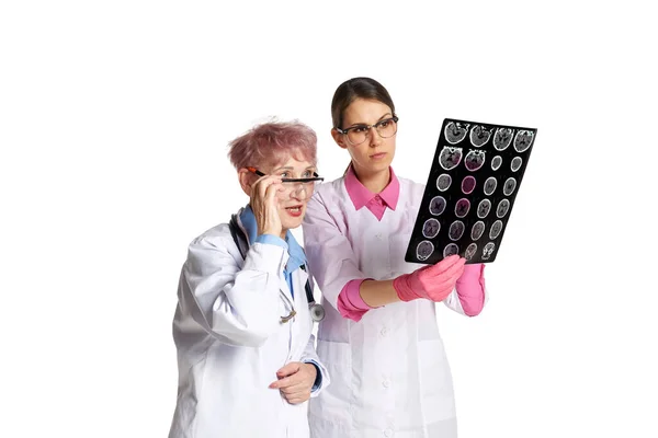 穿着白衣的老年妇女 医生和护士注意地看着X光扫描 对照白底检查健康状况 医疗保健 专业的概念 — 图库照片