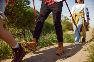 Ormanda yürüyen, sıcak yaz günlerinde yürüyüşe çıkan rahat elbiseli kadın ve erkeklerin görüntüsü. Aktif yaşam tarzı kavramı, doğa, spor ve hobi, arkadaşlık