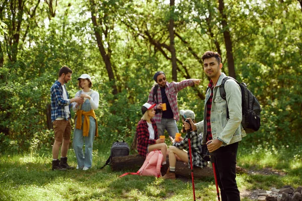 小声でチェックしたシャツを着た若い男が友達とハイキングに行く 若者のグループは 森の中でピクニックをして歩く アクティブなライフスタイル スポーツ 友情の概念 — ストック写真