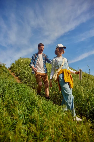 ハッピー 笑顔の友人 カップル 若い男性と女性のカジュアルな服をハイキングに行くには 暖かい夏の日に丘を歩く アクティブなライフスタイル スポーツ 友情の概念 — ストック写真