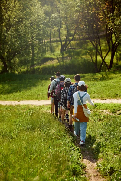 活跃的周末 年轻人 男男女女穿着休闲装背着背包去远足 在森林里散步 在温暖的日子里去绿地公园 积极生活方式 体育和业余爱好的概念 — 图库照片