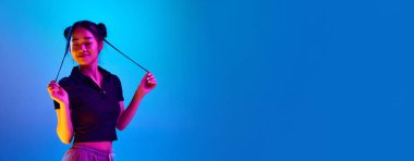 Genç Koreli bir kızın portresi, güzel saç stili gülüyor, mavi stüdyo ışıklarıyla poz veriyor. Duyguların kavramı, yüz ifadesi, gençlik, yaşam tarzı, ilham, reklam. Pankart