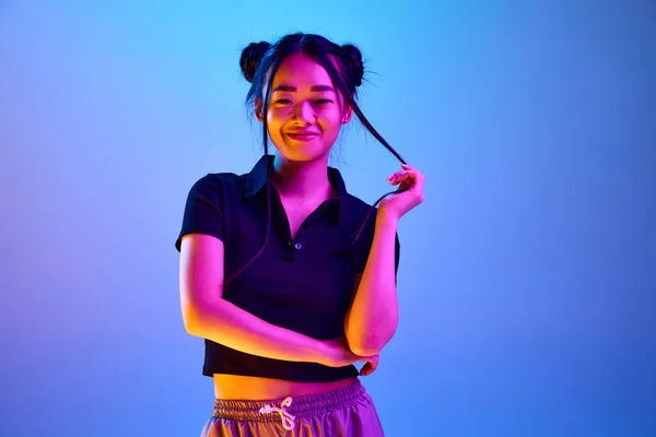 美丽的 年轻的 韩国女孩的肖像 有着时髦的发型 在霓虹灯下在蓝色的工作室背景下摆姿势 面部表情 生活方式 广告的概念 — 图库照片