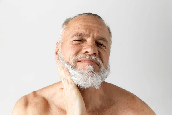 英俊而成熟的男人的画像 灰白的头发 留著胡子 在灰白的背景下半裸的样子 男性美的概念 面部和皮肤护理 日常护理 — 图库照片