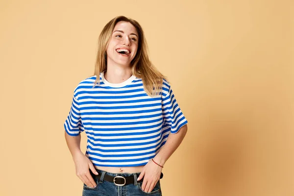 줄무늬 셔츠를 쾌활하게 웃으며 스튜디오 배경에 행복을 느끼는 아름다운 소녀의 — 스톡 사진