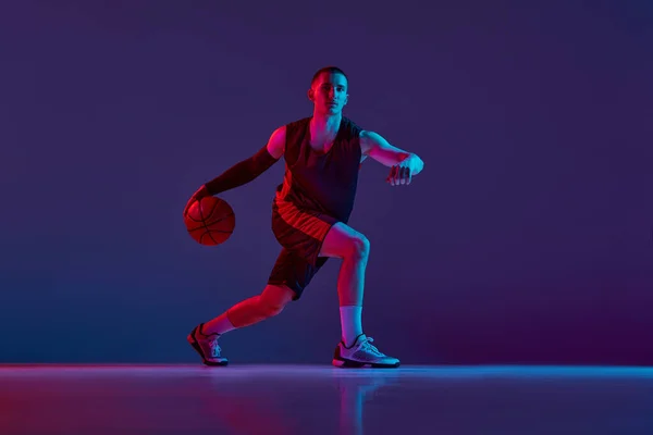 Joven Deportista Jugador Baloncesto Uniforme Durante Juego Driblando Pelota Contra — Foto de Stock