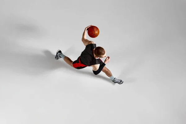 Молодой Спортсмен Сконцентрированный Баскетболист Движении Время Игры Сером Фоне Студии — стоковое фото