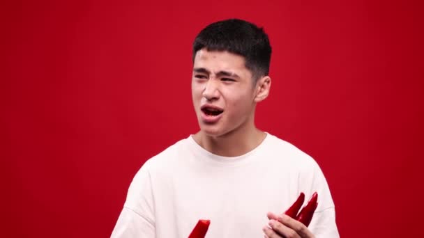 Grimace Ansikte Ung Asiatisk Man Äter Röd Varm Chili Paprika — Stockvideo
