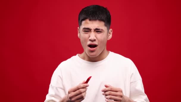 Brændende Mund Ung Asiatisk Mand Spiser Rød Hot Chili Peberfrugter – Stock-video