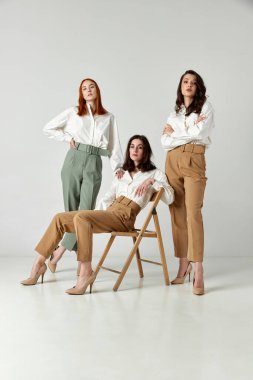 Işık stüdyosunun arka planında poz veren zarif, şık ve çekici genç kadınların portresi. Zarif moda kavramı, kadın güzelliği, iş, alışveriş, satış, reklam