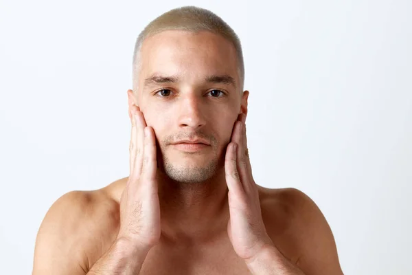 白いスタジオの背景に肌の後の世話をするクリア 染みのない顔を持つハンサムな若い男のクローズアップ肖像画 男性の美しさ スキンケア 健康の概念 広告のコピースペース — ストック写真