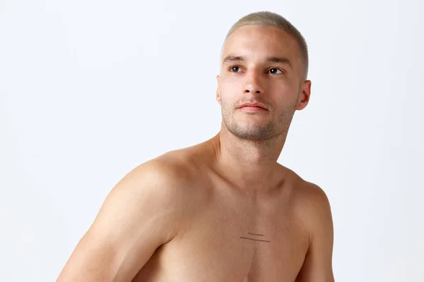 白いスタジオの背景に無表情にポーズをとる若いハンサムな男の肖像 健康な肌を保つ男性モデル 男性の美しさ スキンケア 健康の概念 広告のコピースペース — ストック写真