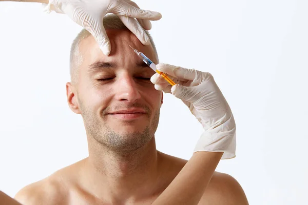 Stilig Ung Man Gör Kosmetologiska Ansikte Injektioner Pannan Mot Vit — Stockfoto
