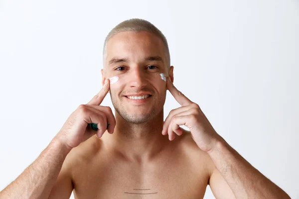 Retrato Jovem Bonito Sorrindo Homem Cuidando Pele Com Creme Hidratante — Fotografia de Stock