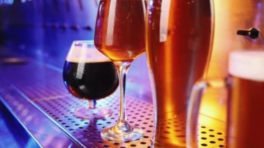 Bira bardaklarının koyu ve lager biralı yakın plan görüntüsü. Seçici odaklanma. Soğuk, soğuk bir içecek. İçecek bir şeyler. Bar, bar atmosferi. İçki, parti, tat, rahatlama kavramı. Ad