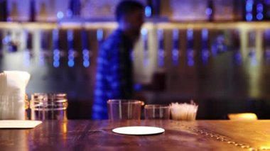 Genç adam, damalı gömlekli barmen müşteriye büyük bardakta bira servisi yapıyor. Bar ziyareti, içki içilen bar. İçki, parti, tat, rahatlama kavramı. Ad