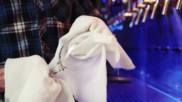 酒保在酒吧用毛巾擦拭啤酒杯 背景是霓虹灯下的酒吧 准备好了 准备好了酒精饮料的概念 — 图库视频影像