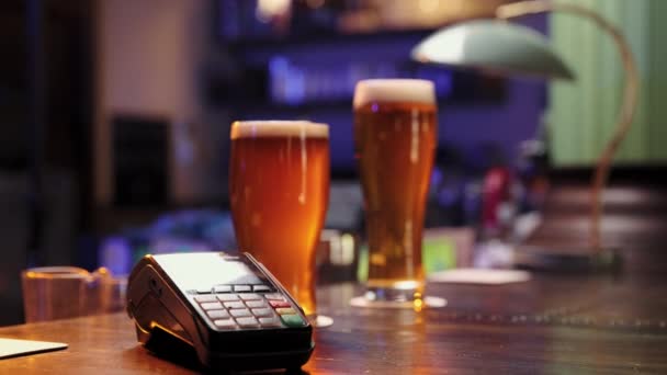 人类的手支付与接触支付啤酒在酒吧 调酒师在杯子里放啤酒 重新审议 酒精饮料的概念 — 图库视频影像