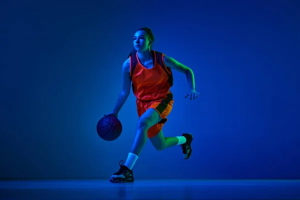 Allenamento Atleta Pallacanestro Femminile Concentrato Pallone Dribbling Sullo Sfondo Blu — Foto Stock
