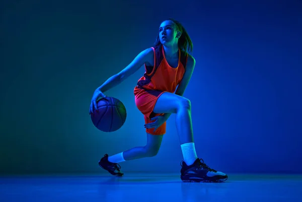 勝つ動機 ネオンの青のスタジオの背景を背景にゲーム中に運動中の若い女性バスケットボール選手 プロスポーツ アクションと運動 ゲーム 広告の概念 — ストック写真
