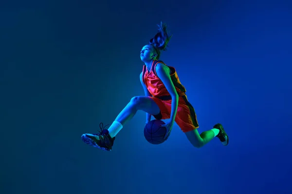 Молода Спортивна Дівчина Баскетболіст Стрибає Ячем Фоні Синього Студійного Фону — стокове фото