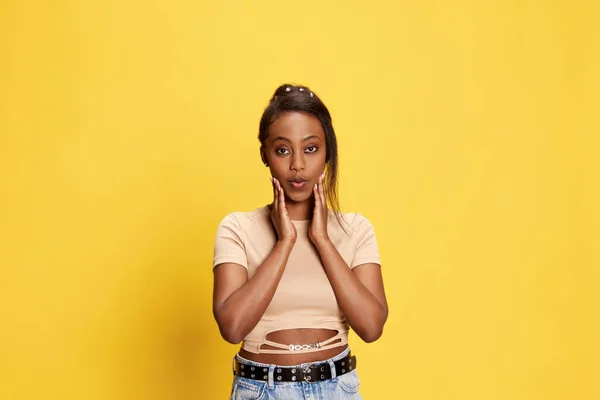 形象迷人 漂亮的年轻非洲姑娘穿着休闲装 在黄色的工作室背景下摆出惊讶的面孔 生活方式 人类情感 广告的概念 — 图库照片