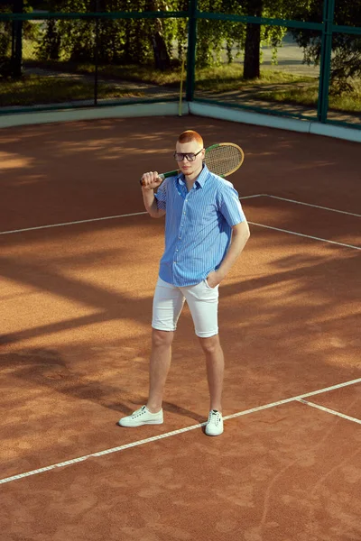 身穿时髦休闲装 戴着眼镜的英俊红头发年轻人在露天网球场摆姿势的全长头像 体育概念 积极的生活方式 业余爱好 闲暇时间 — 图库照片