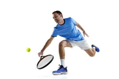 Aktif, üniformalı, tenis oynayan, beyaz arka planda tek başına oynanan oyun sırasında raketle top oynayan bir adam. Spor anlayışı, aktif yaşam tarzı, oyun, hobi, sağlık, dinamik, reklam